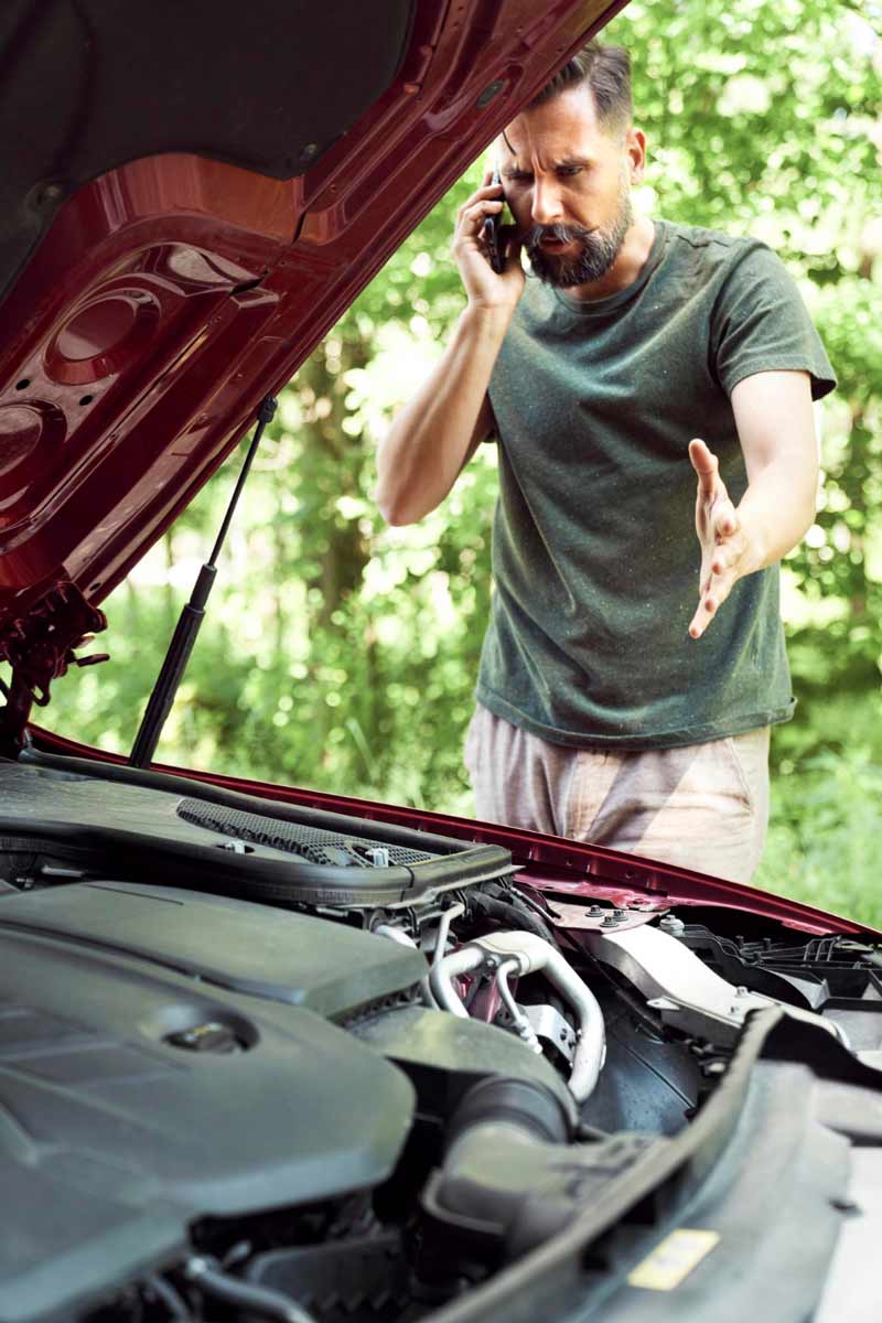 Junger Mann prüft Getriebeschaden bei Schrottauto Ankauf Wilhelmshaven